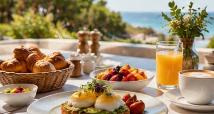 Desayuno con huevos benedictinos, frutas y jugo frente al mar